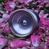 Mk1 Brass Exia Bi-metal YoYo, Lilac w/ brass rings, on ground with flower petals